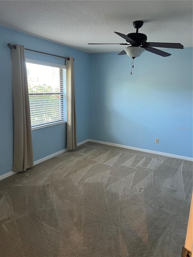 spare room with ceiling fan, carpet flooring, and a textured ceiling