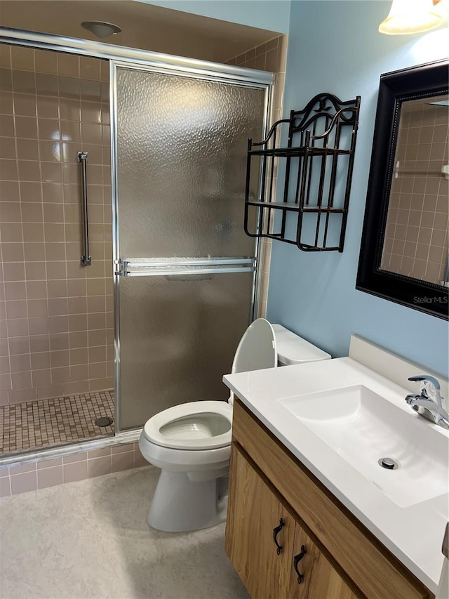 bathroom with vanity, toilet, tile patterned flooring, and a shower with door