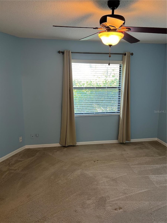 carpeted spare room with ceiling fan and a textured ceiling