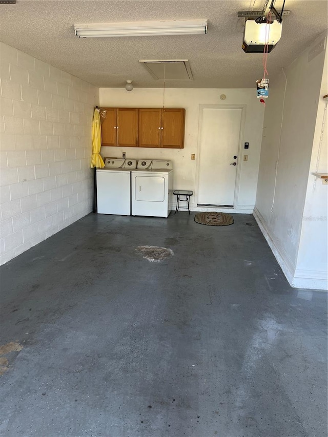 garage with a garage door opener and separate washer and dryer