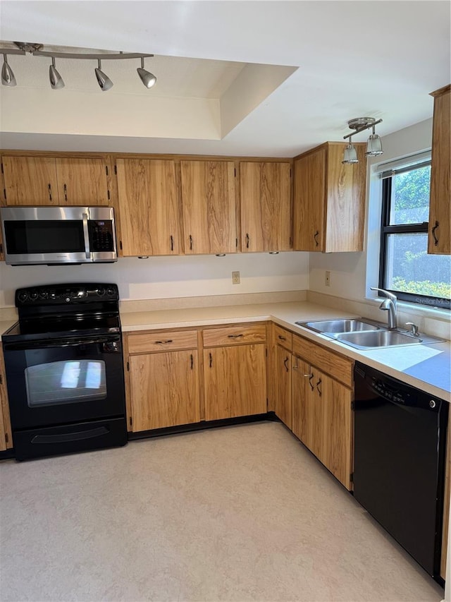 kitchen featuring rail lighting, sink, and black appliances