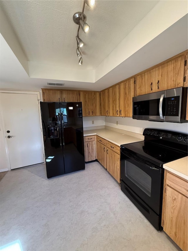 kitchen with black appliances, a raised ceiling, and a textured ceiling