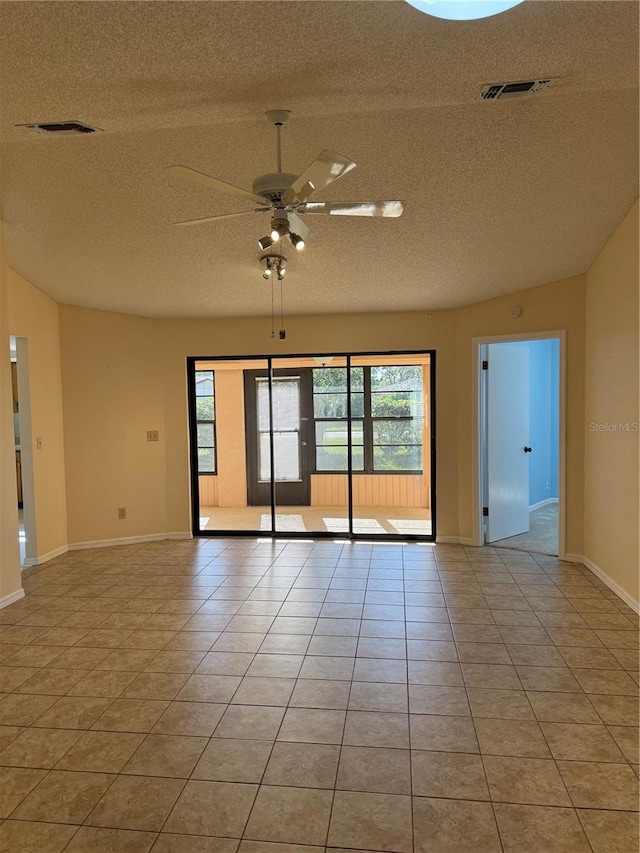 unfurnished room with light tile patterned floors, a textured ceiling, visible vents, and a ceiling fan