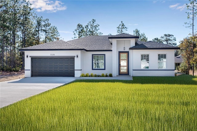 view of front of home with a front yard and a garage