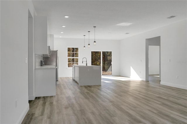 unfurnished living room featuring light wood-type flooring and sink