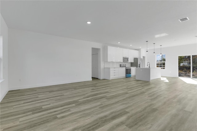 unfurnished living room with light wood-type flooring and sink