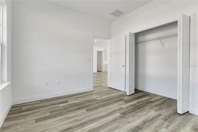 unfurnished bedroom with light hardwood / wood-style floors and a closet