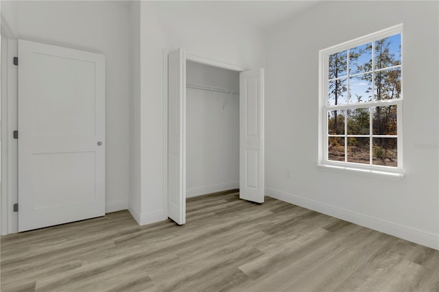 unfurnished bedroom with a closet and light hardwood / wood-style flooring