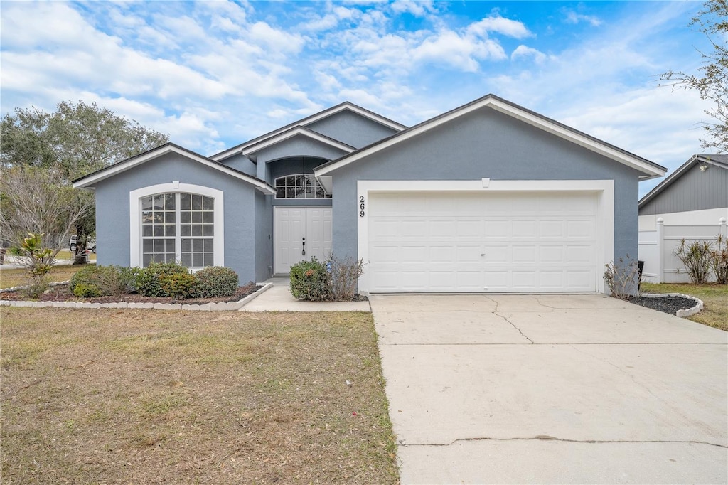 single story home featuring a front yard and a garage