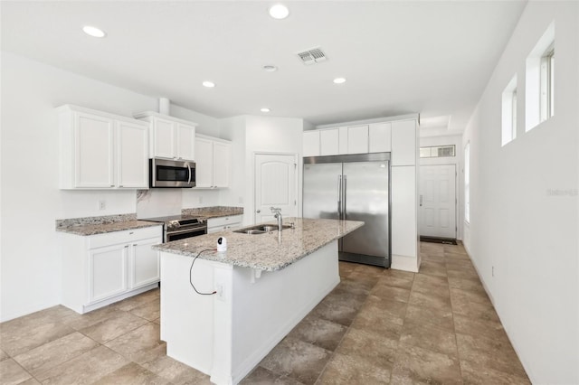 kitchen with a center island with sink, sink, white cabinets, and stainless steel appliances