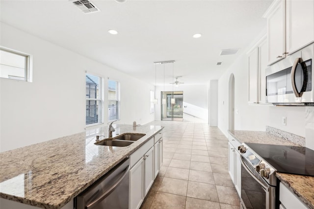 kitchen featuring white cabinetry, a kitchen island with sink, sink, and stainless steel appliances