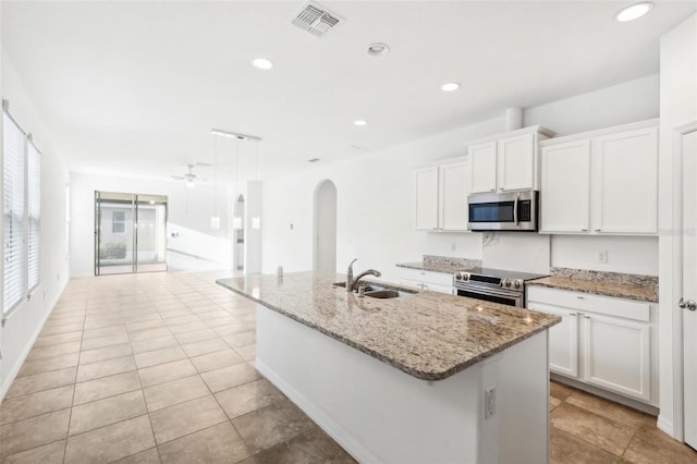 kitchen with a kitchen island with sink, sink, appliances with stainless steel finishes, decorative light fixtures, and white cabinetry