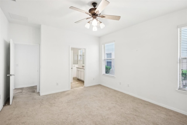 unfurnished bedroom featuring connected bathroom, ceiling fan, and light colored carpet