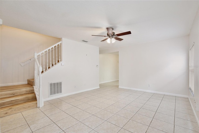 tiled spare room featuring ceiling fan