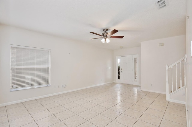 tiled spare room with ceiling fan