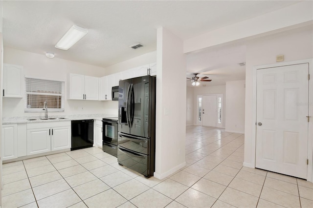 kitchen with ceiling fan, sink, black appliances, light tile patterned floors, and white cabinets