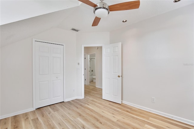 unfurnished bedroom featuring ceiling fan, vaulted ceiling, light wood-type flooring, and a closet