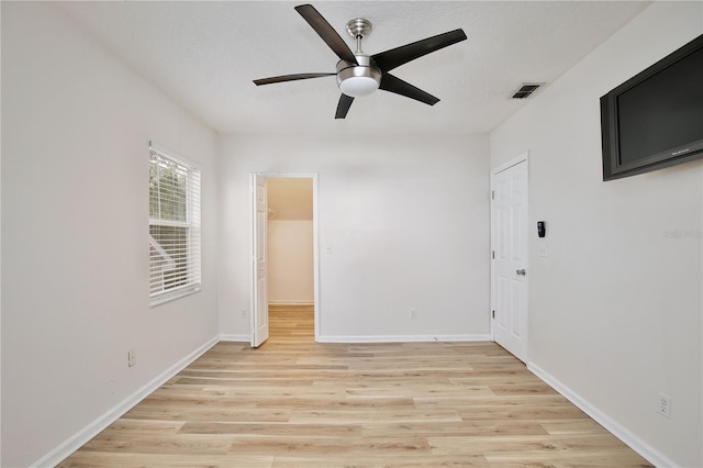 unfurnished room with ceiling fan and light wood-type flooring