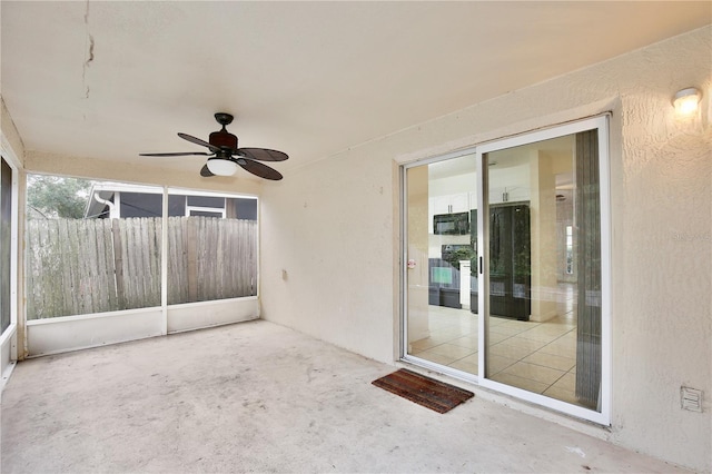 unfurnished sunroom with ceiling fan