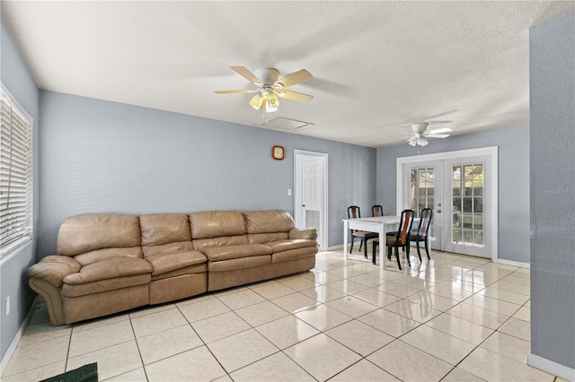 tiled living room featuring french doors, a textured ceiling, and ceiling fan