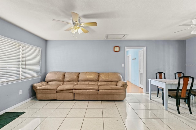 tiled living room featuring a textured ceiling and ceiling fan