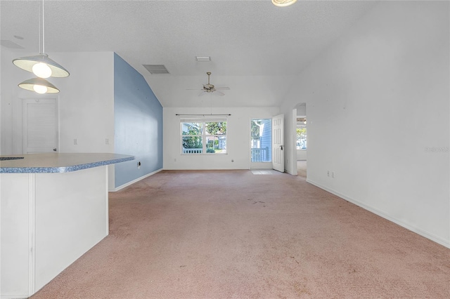 unfurnished living room with light carpet, ceiling fan, and vaulted ceiling