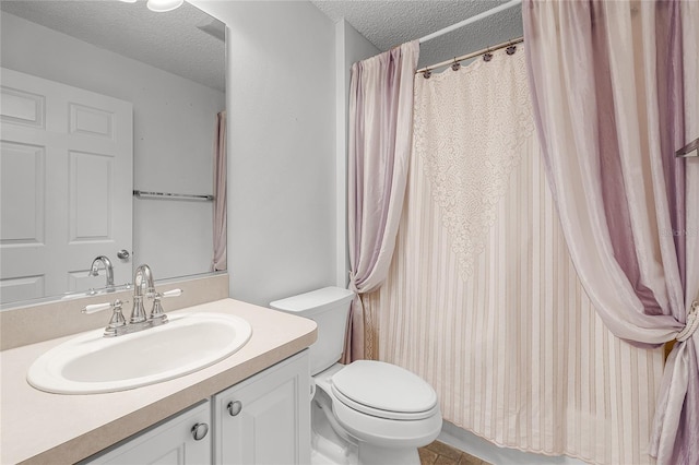 bathroom featuring vanity, toilet, and a textured ceiling