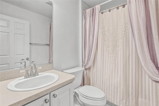 bathroom with vanity, a textured ceiling, and toilet