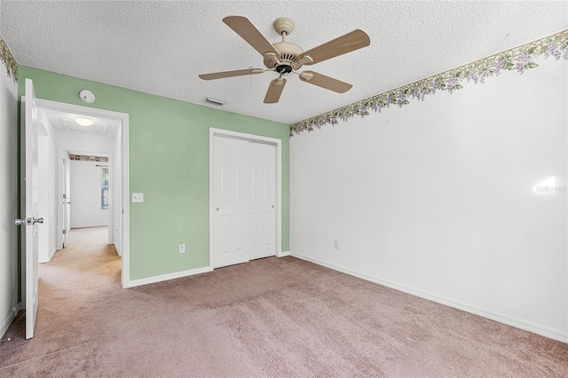 unfurnished bedroom featuring a textured ceiling, ceiling fan, light carpet, and a closet