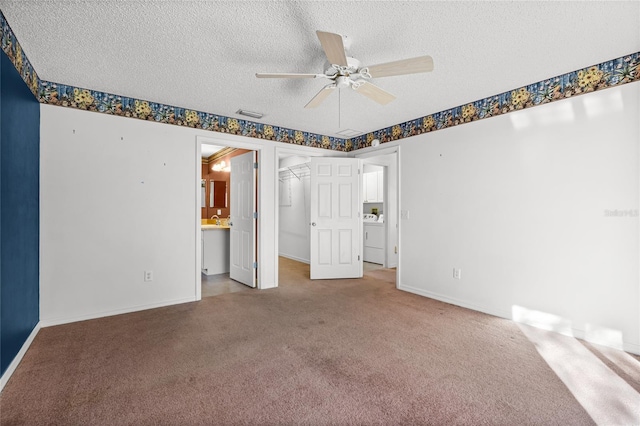 unfurnished bedroom featuring ceiling fan, washer / dryer, a textured ceiling, and light carpet