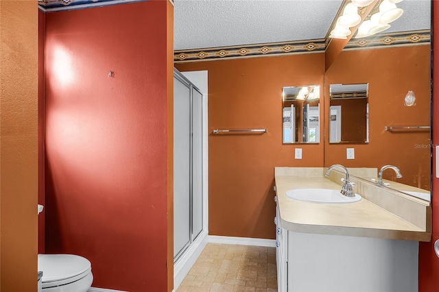 bathroom featuring a shower with door, vanity, a textured ceiling, and toilet