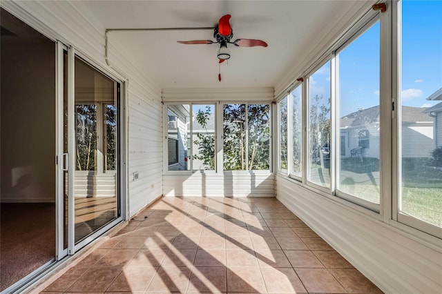 unfurnished sunroom with ceiling fan and plenty of natural light