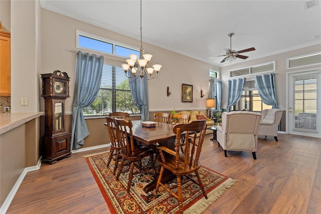 dining space featuring a wealth of natural light, crown molding, and dark wood-type flooring