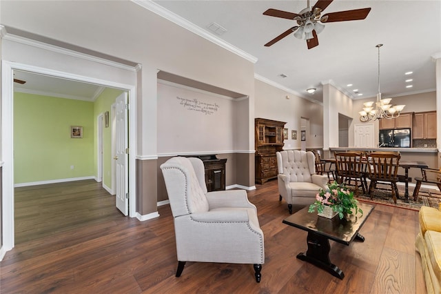 living room featuring ceiling fan with notable chandelier, dark hardwood / wood-style flooring, and crown molding