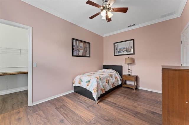 bedroom with dark hardwood / wood-style flooring, ceiling fan, and ornamental molding