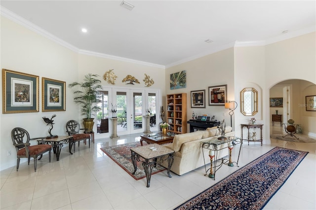 living room featuring light tile patterned flooring, ornamental molding, a towering ceiling, and french doors