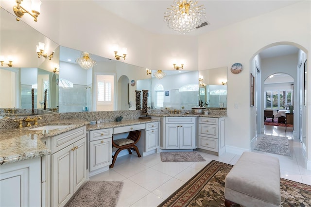 bathroom with tile patterned flooring, a notable chandelier, a healthy amount of sunlight, and walk in shower