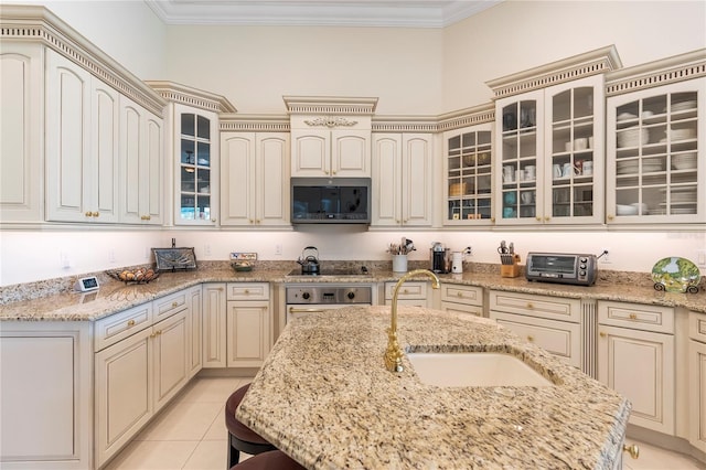 kitchen featuring light stone countertops, sink, stainless steel appliances, and cream cabinetry