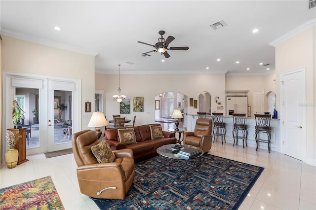 living room with light tile patterned floors, ceiling fan with notable chandelier, french doors, and crown molding