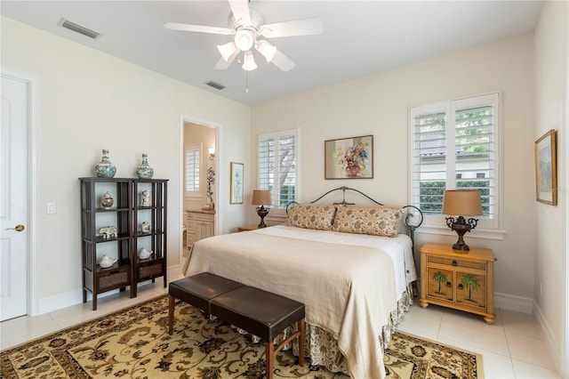 tiled bedroom featuring ensuite bath and ceiling fan