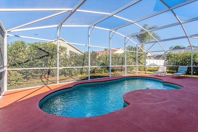 view of swimming pool featuring a patio and glass enclosure