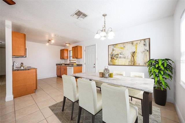 tiled dining room with a chandelier and a textured ceiling