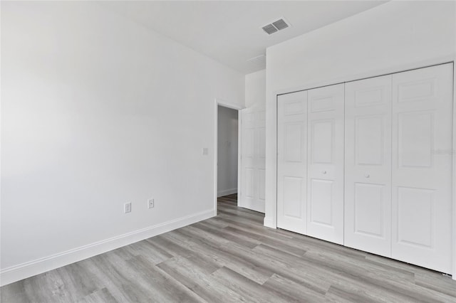 unfurnished bedroom featuring light hardwood / wood-style floors and a closet