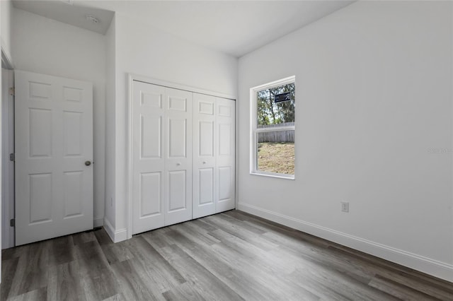 unfurnished bedroom featuring hardwood / wood-style flooring and a closet