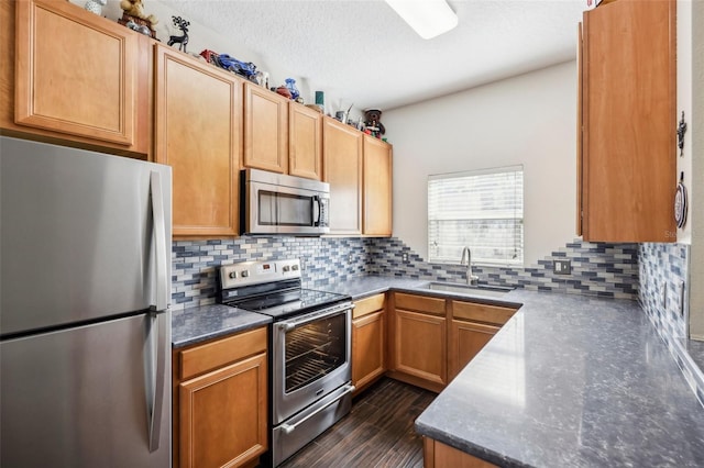 kitchen featuring dark hardwood / wood-style flooring, backsplash, a textured ceiling, stainless steel appliances, and sink