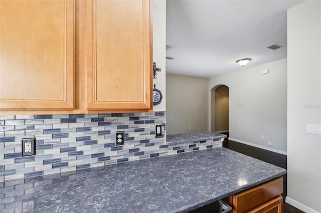 kitchen featuring tasteful backsplash and dark stone counters