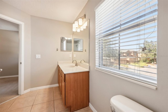 bathroom with toilet, vanity, and tile patterned floors