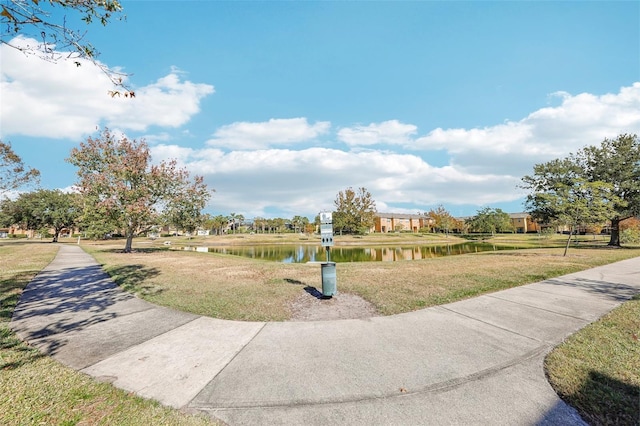 view of home's community with a lawn and a water view