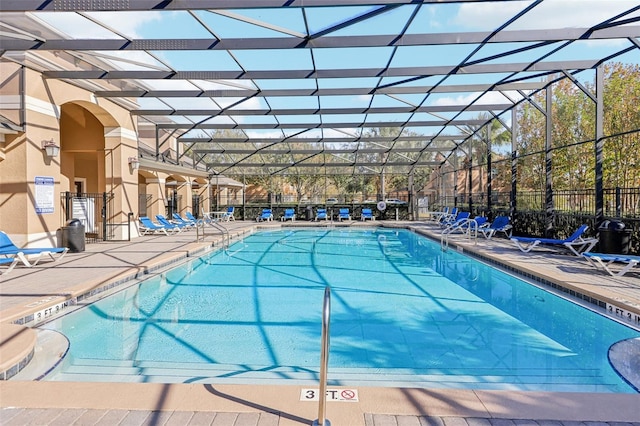 view of pool featuring glass enclosure and a patio