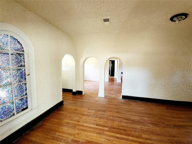 corridor with dark hardwood / wood-style flooring and vaulted ceiling